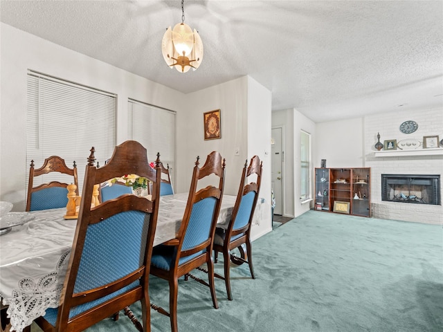 carpeted dining room featuring a textured ceiling and a fireplace