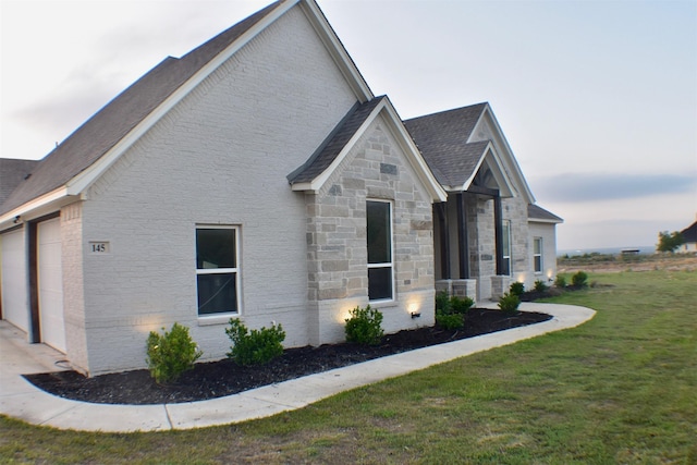 145 Overlook Dr, Aledo, TX 76008 - view of side of property with a lawn, an attached garage, a shingled roof, and stone siding