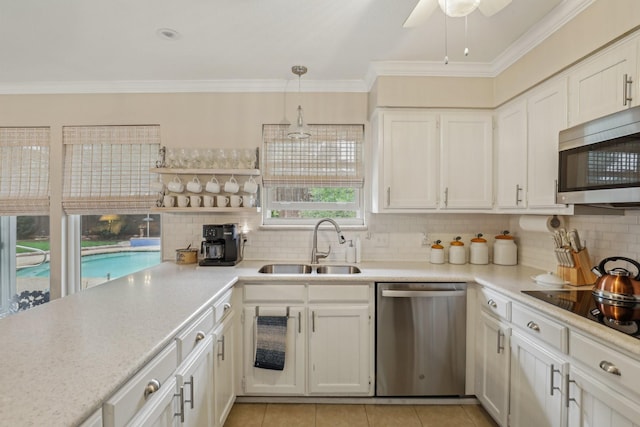 5008 Caliente Dr, Arlington, TX 76017 - kitchen with stainless steel appliances, a sink, light countertops, decorative backsplash, and white cabinetry