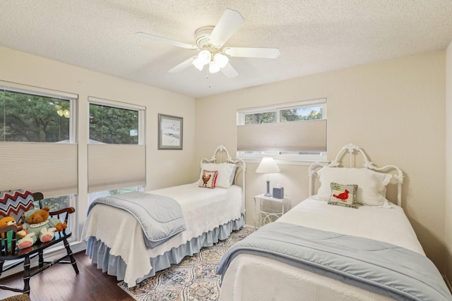 5008 Caliente Dr, Arlington, TX 76017 - bedroom with dark wood-type flooring, a textured ceiling, a ceiling fan, and a baseboard radiator