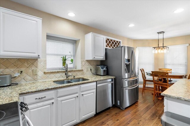 2098 Amber Ct, Lewisville, TX 75067 - kitchen with appliances with stainless steel finishes, a sink, white cabinets, dark wood-style floors, and tasteful backsplash