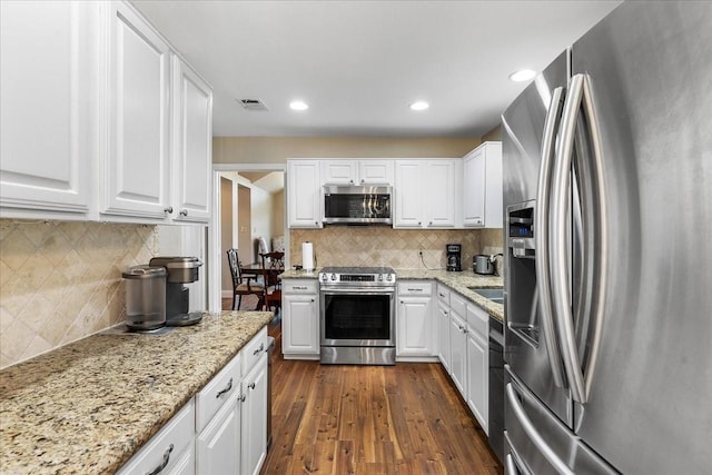 2098 Amber Ct, Lewisville, TX 75067 - kitchen with stainless steel appliances, tasteful backsplash, white cabinets, dark wood-style floors, and recessed lighting