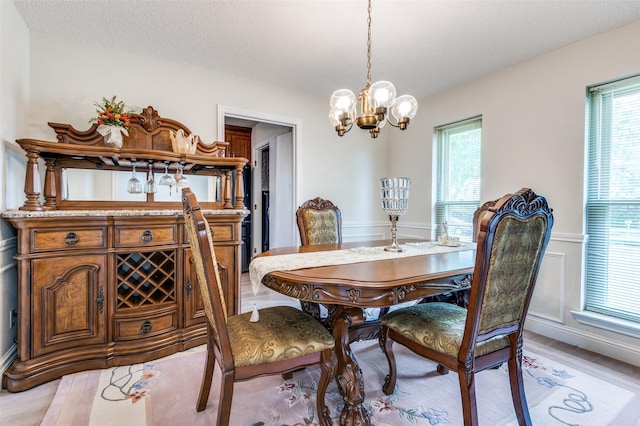 1513 Silverleaf Dr, Carrollton, TX 75007 - dining space featuring a chandelier, plenty of natural light, light wood-type flooring, and wainscoting