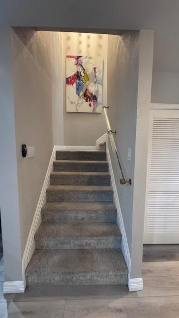 stairs with baseboards and wood finished floors