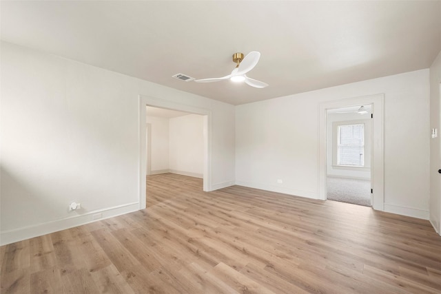 empty room featuring a ceiling fan, light wood finished floors, and baseboards