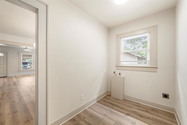 laundry room with hookup for an electric dryer, washer hookup, light wood-style flooring, and baseboards