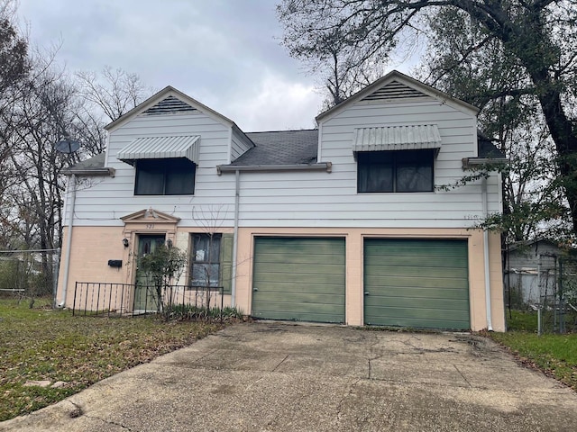 view of front of home featuring roof with shingles, driveway, a garage, and fence