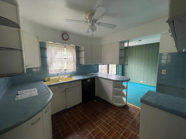 kitchen with a sink, brick patterned floors, dishwasher, ceiling fan, and open shelves