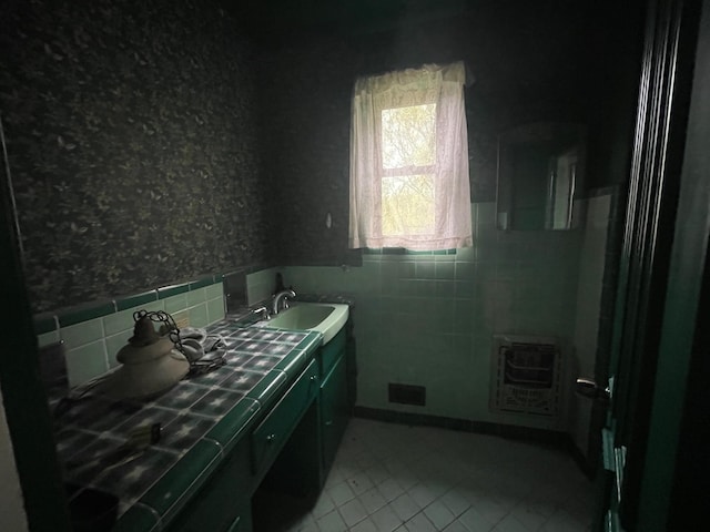 bathroom with tile walls, tile patterned flooring, wainscoting, double vanity, and heating unit