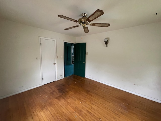 unfurnished bedroom with hardwood / wood-style floors, baseboards, and ceiling fan