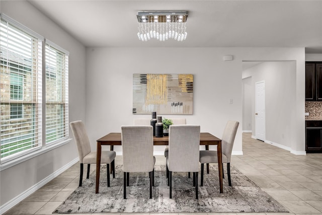 3433 Alamosa River Dr, Celina, TX 75078 - dining space with a chandelier, healthy amount of natural light, light tile patterned floors, and baseboards