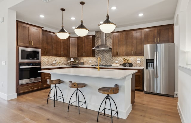 2824 Tophill Dr, Celina, TX 75009 - kitchen featuring stainless steel appliances, wall chimney exhaust hood, backsplash, light countertops, and a breakfast bar area