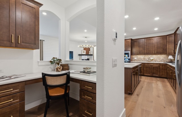 2824 Tophill Dr, Celina, TX 75009 - kitchen with light wood-type flooring, dark brown cabinets, tasteful backsplash, recessed lighting, and light countertops