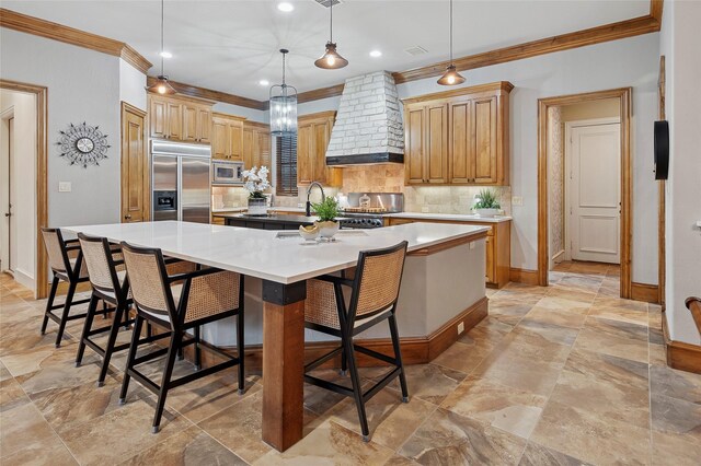 4290 Castle Bank Ln, Frisco, TX 75033 - kitchen with built in appliances, premium range hood, crown molding, baseboards, and a spacious island