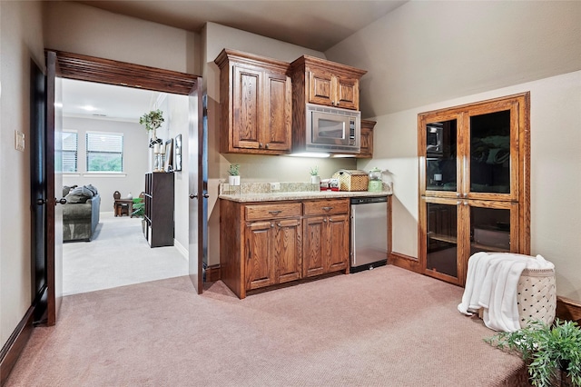 4290 Castle Bank Ln, Frisco, TX 75033 - kitchen featuring appliances with stainless steel finishes, light carpet, light countertops, and brown cabinetry