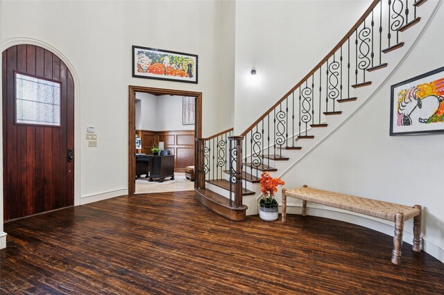 4290 Castle Bank Ln, Frisco, TX 75033 - foyer entrance with wood finished floors, a towering ceiling, stairway, arched walkways, and baseboards