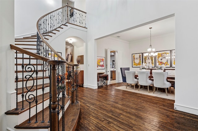 4290 Castle Bank Ln, Frisco, TX 75033 - entrance foyer with wood finished floors, stairway, arched walkways, a high ceiling, and ornamental molding