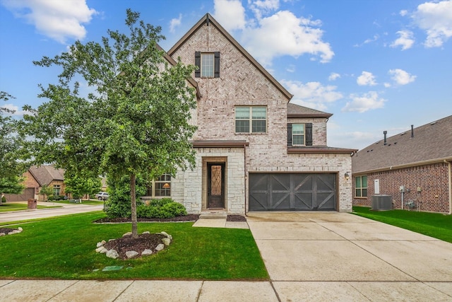 traditional home with brick siding, central AC unit, a garage, a front yard, and driveway