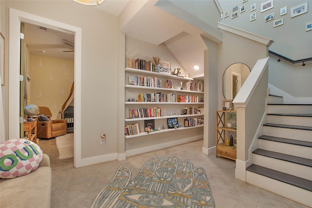 living area featuring stairs, built in features, and lofted ceiling