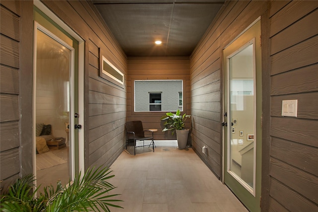 doorway to outside featuring wooden walls