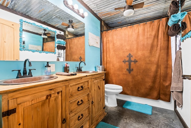 bathroom with ceiling fan, toilet, double vanity, and concrete floors