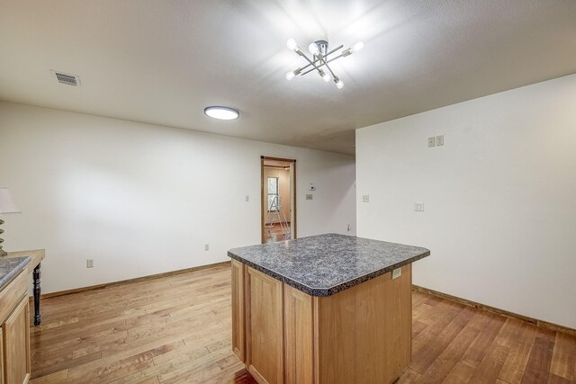 41 Crestline Ct, Nocona, TX 76255 - kitchen with light wood-style floors, dark countertops, a center island, and a chandelier