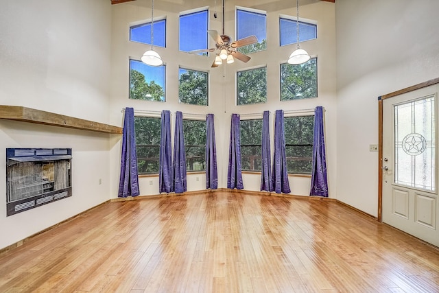 41 Crestline Ct, Nocona, TX 76255 - unfurnished living room featuring a ceiling fan, hardwood / wood-style floors, a towering ceiling, and a fireplace