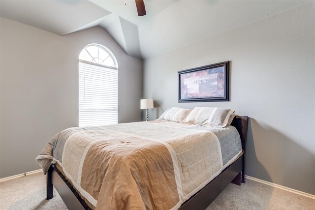 carpeted bedroom with vaulted ceiling, baseboards, and a ceiling fan