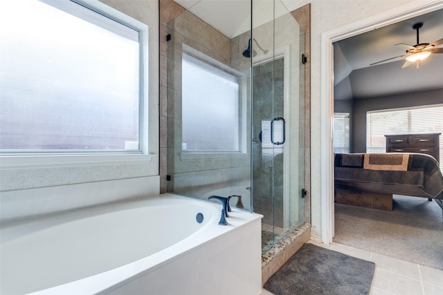 ensuite bathroom featuring healthy amount of natural light, a shower stall, ceiling fan, and tile patterned floors