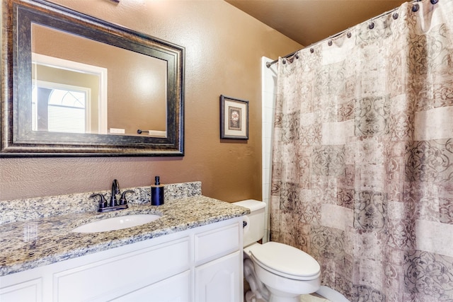 full bathroom with toilet, vanity, a textured wall, and curtained shower