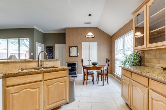 kitchen featuring a sink, light brown cabinetry, wine cooler, glass insert cabinets, and light tile patterned floors