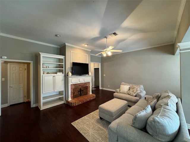 living area with a ceiling fan, a brick fireplace, dark wood-style flooring, ornamental molding, and baseboards