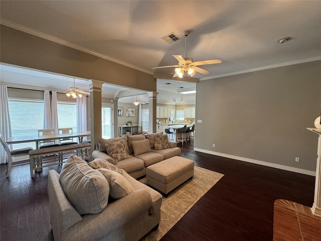 living room with decorative columns, ceiling fan, healthy amount of natural light, and crown molding