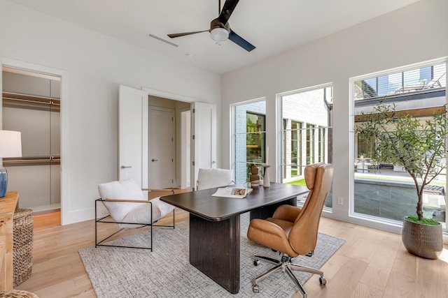 office area featuring light wood-type flooring, plenty of natural light, and ceiling fan
