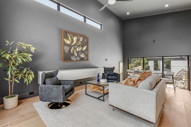 living room featuring a towering ceiling, wood finished floors, a ceiling fan, and recessed lighting