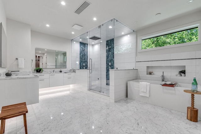 bathroom featuring a shower stall, a freestanding bath, vanity, recessed lighting, and marble finish floors