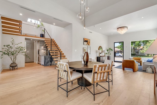 dining space with stairway, light wood-style floors, recessed lighting, baseboards, and a chandelier