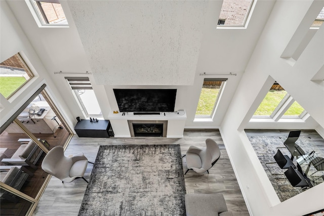 5160 Statesman Ln, Frisco, TX 75036 - living area with a towering ceiling, wood finished floors, and a glass covered fireplace