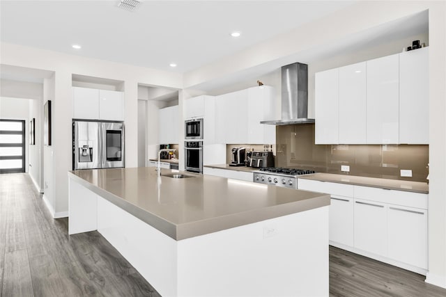 5160 Statesman Ln, Frisco, TX 75036 - kitchen with appliances with stainless steel finishes, wall chimney range hood, a sink, modern cabinets, and dark wood-type flooring