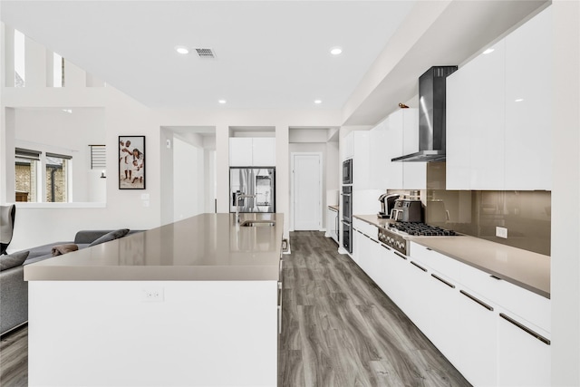 5160 Statesman Ln, Frisco, TX 75036 - kitchen with wall chimney exhaust hood, modern cabinets, stainless steel appliances, a sink, and wood finished floors