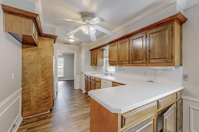 kitchen featuring a sink, ceiling fan, ornamental molding, brown cabinets, and white dishwasher