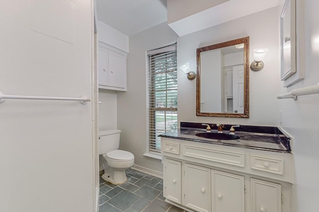 bathroom featuring toilet, vanity, and tile patterned flooring