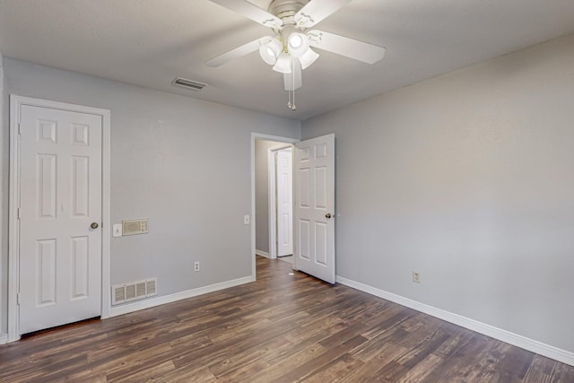 unfurnished bedroom with dark wood-type flooring, baseboards, and a ceiling fan