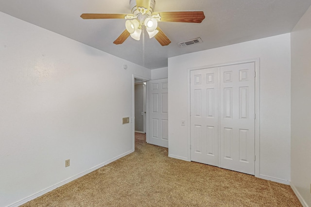 unfurnished bedroom featuring light carpet, baseboards, a closet, and a ceiling fan