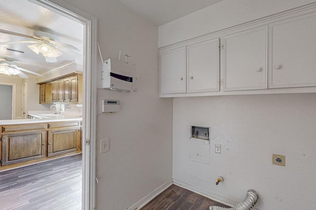washroom featuring cabinet space, hookup for an electric dryer, wood finished floors, a ceiling fan, and baseboards