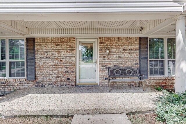 doorway to property with brick siding