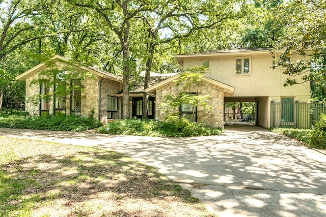 410 E Beady Rd, Arlington, TX 76006 - view of front of house with stone siding, concrete driveway, a carport, and stucco siding