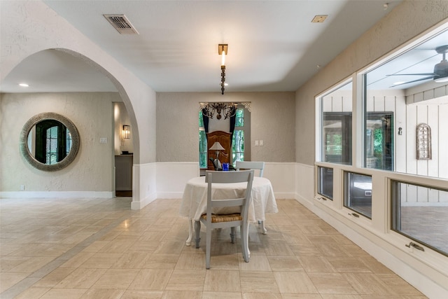 410 E Beady Rd, Arlington, TX 76006 - dining area with a textured wall, arched walkways, a ceiling fan, and wainscoting