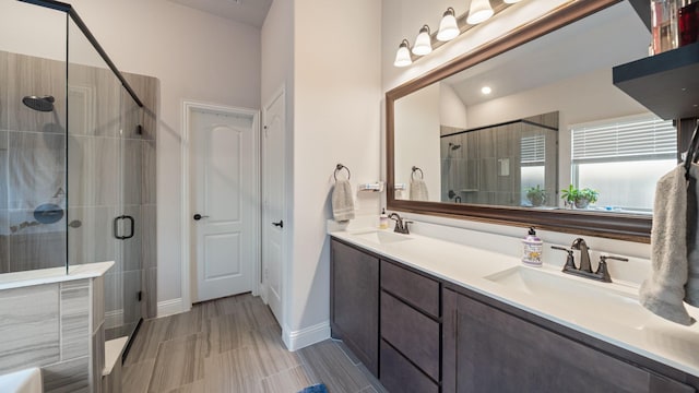 bathroom featuring a shower stall, double vanity, and baseboards