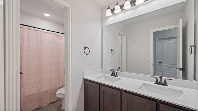 bathroom with toilet, double vanity, and a shower with shower curtain